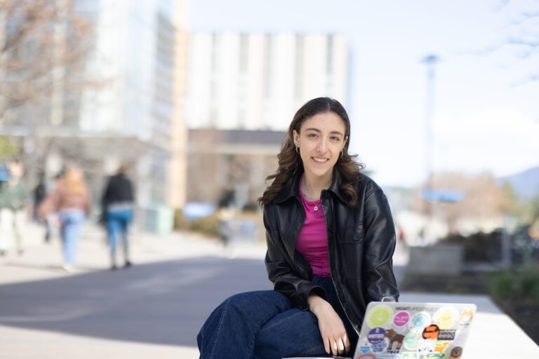Abby with her laptop on the UBC Okanagan campus