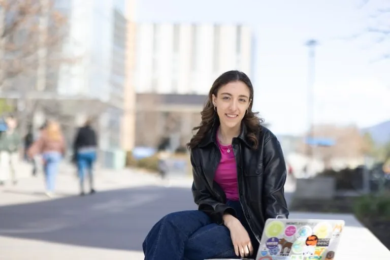 Abby with her laptop on the UBC Okanagan campus