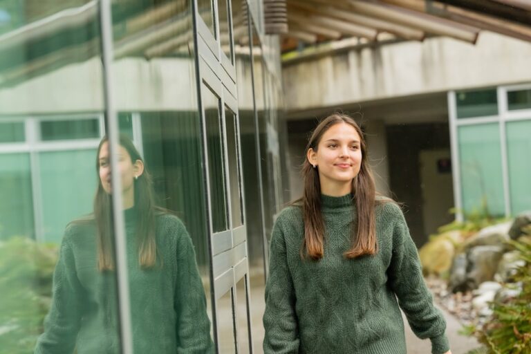 Jamie walking outside the Longhouse on the Vancouver campus