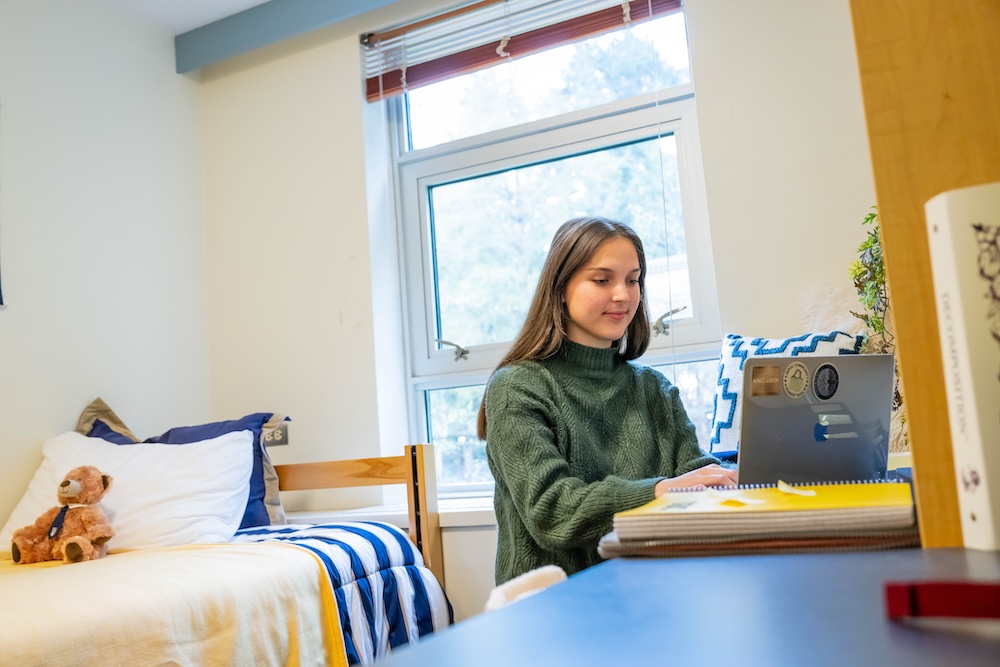 Jamie doing school work on her laptop in her dorm room.