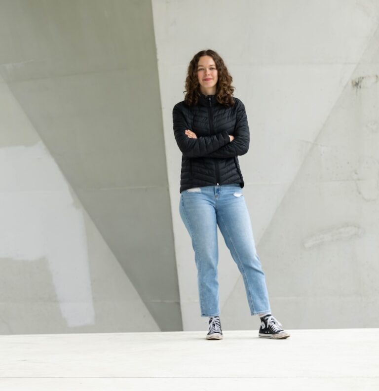 Elleda standing in front of a concrete wall