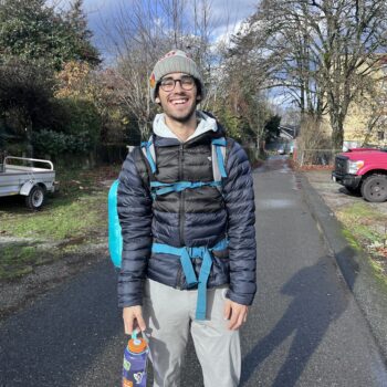 Hammad J stands in road with a pack and water bottle.