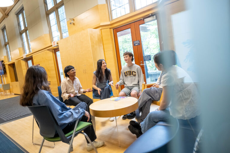 group of students sitting and talking around a small table