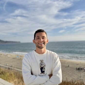 Danilo on a beach wearing a Yale Law School tshirt